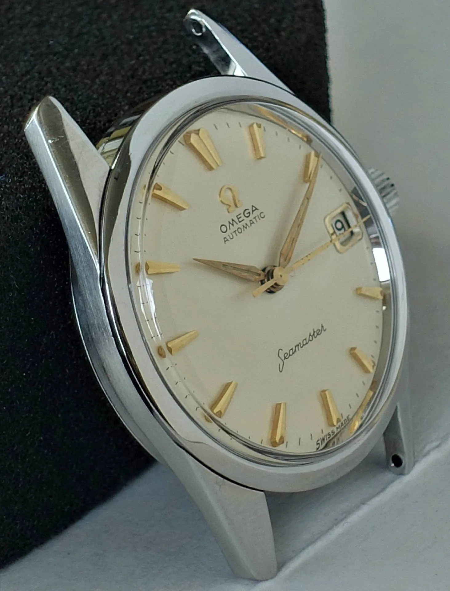 Silberfarbene Armbanduhr mit beigem Zifferblatt und goldfarbenen Indizes und Zeigern.