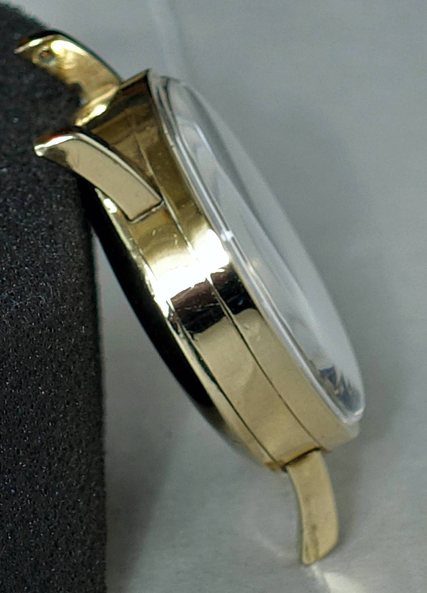 Detailansicht einer eleganten goldenen Armbanduhr mit durchsichtiger Glasoberfläche
