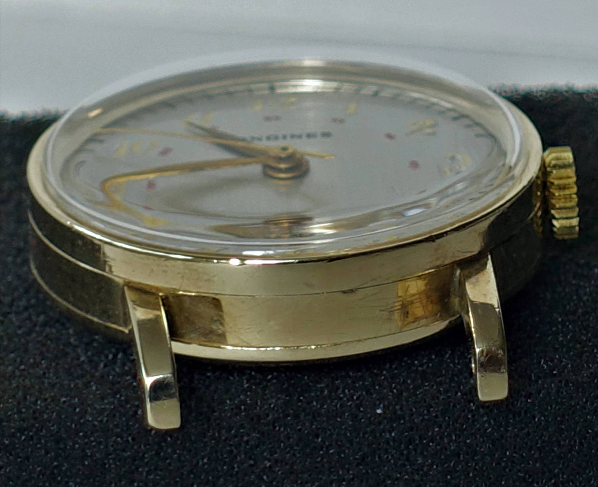 Detailaufnahme einer goldenen Armbanduhr von Longines mit einem klaren Ziffernblatt