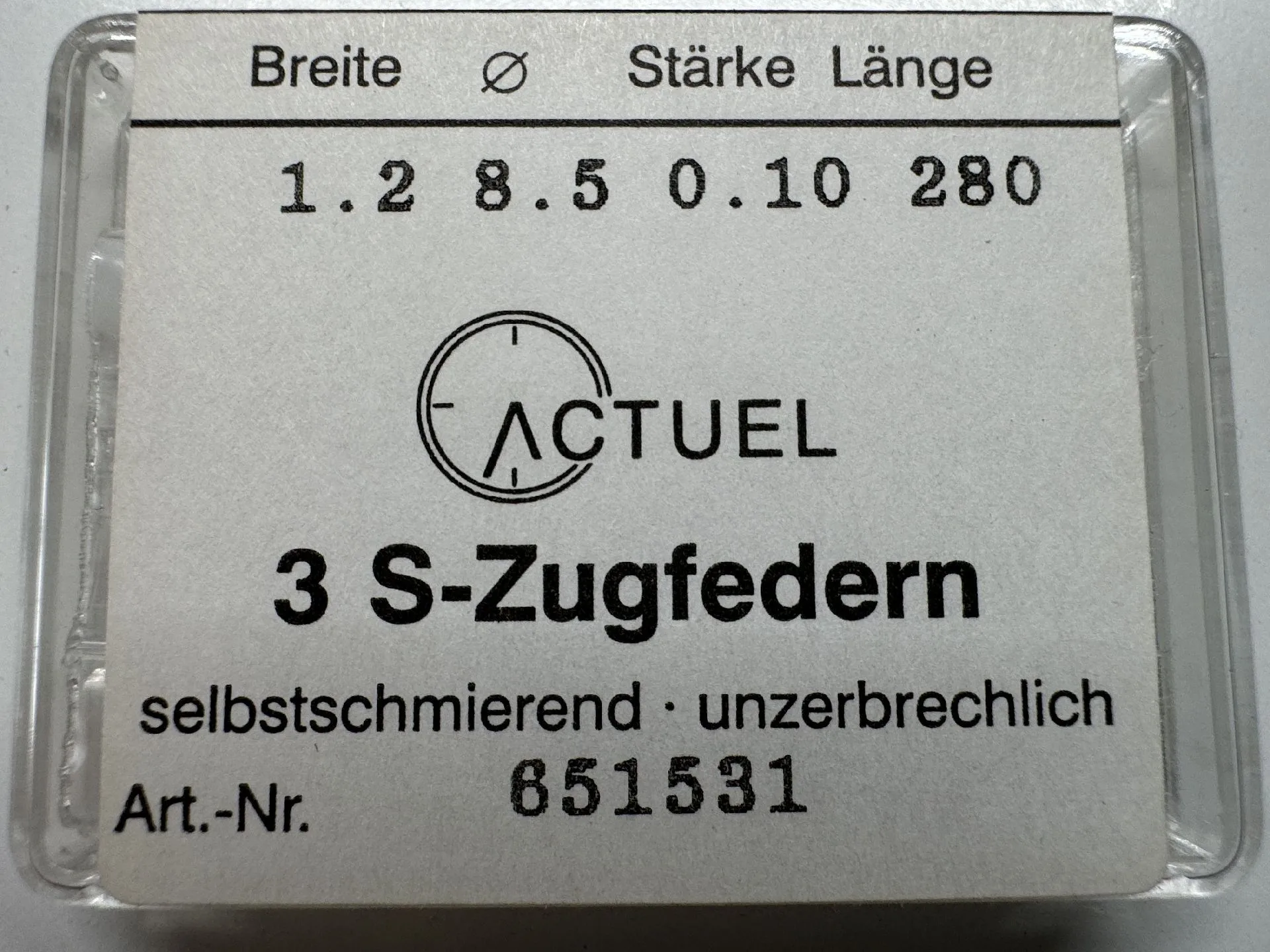Verpackung mit drei Zugfedern für Uhrwerke, beschriftet mit technischen Angaben.