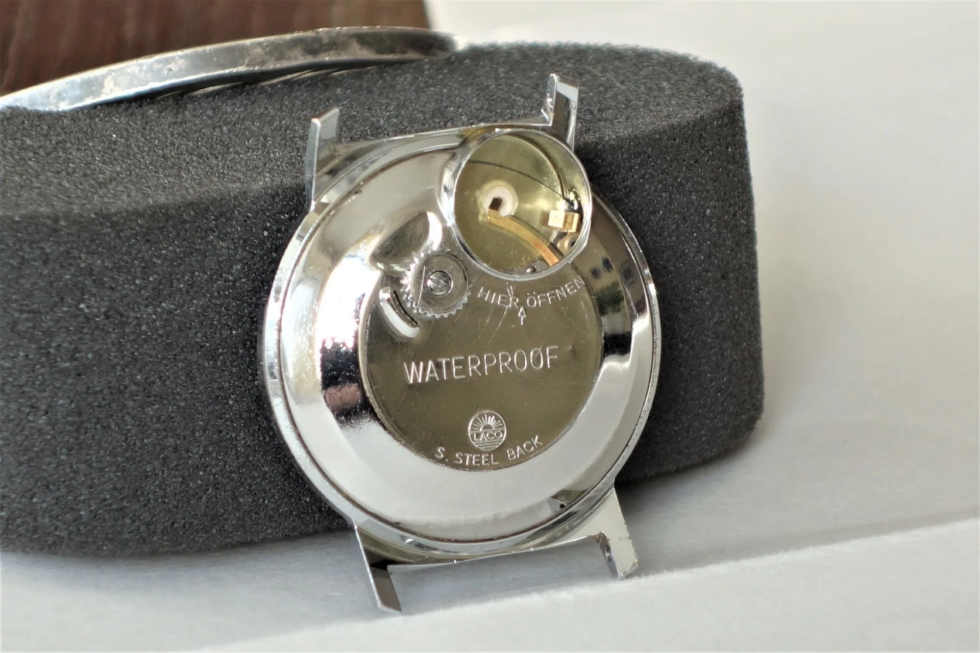 Uhrengehäuse mit Rückseite Rundes Metallgehäuse einer Armbanduhr mit verschraubtem Rückdeckel und sichtbarem Uhrwerk.