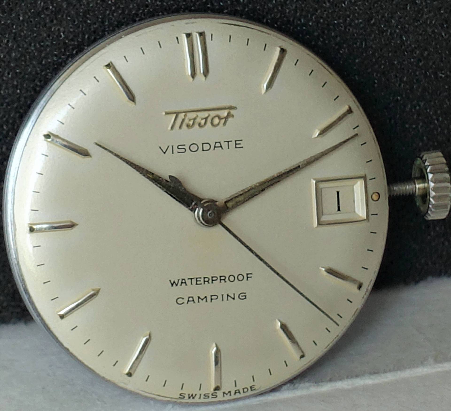 Rundes Uhrwerk mit silberfarbenem Zifferblatt, Zeigern und Datumsanzeige, Aufschrift "Tissot Visodate".