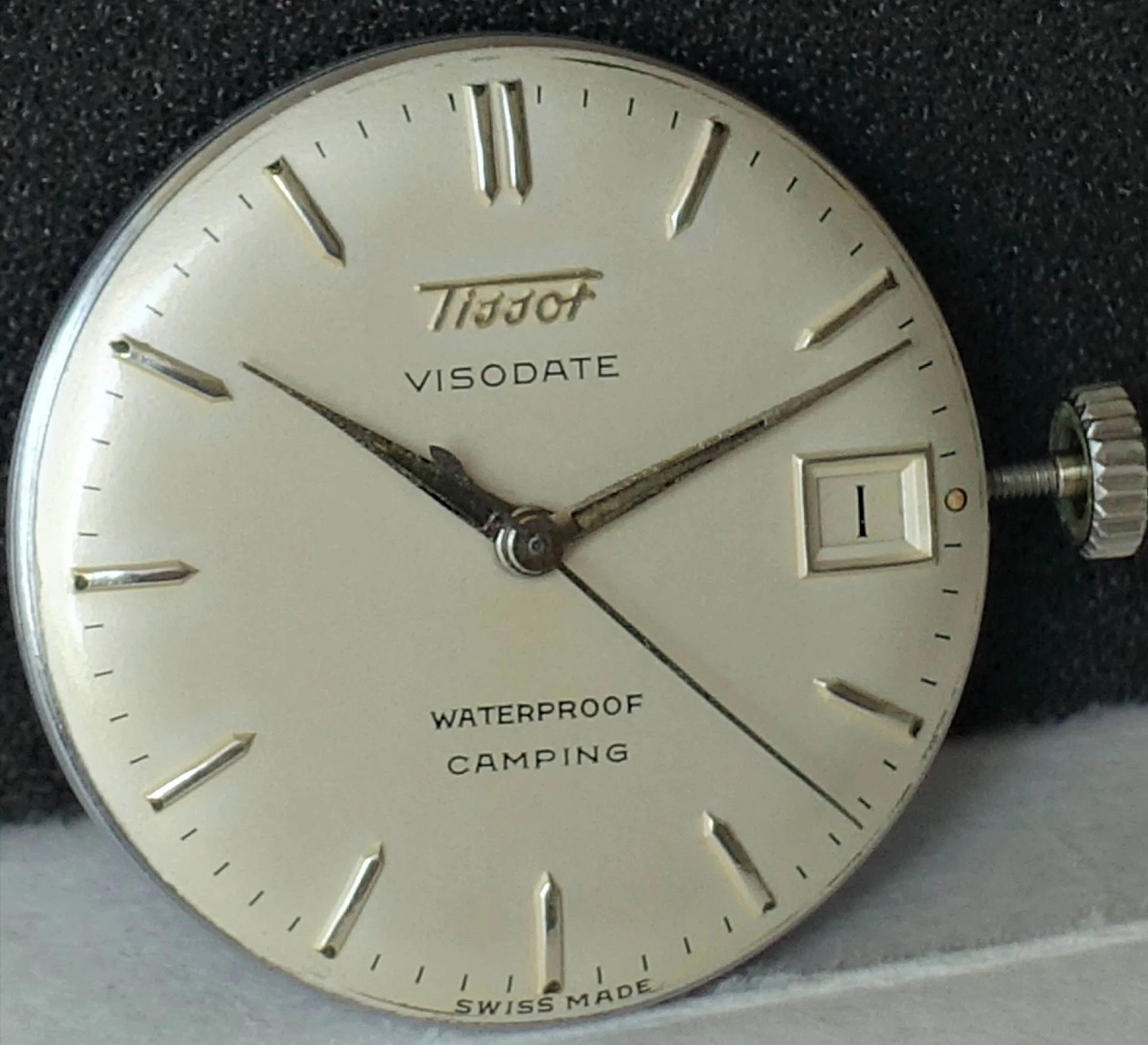 Rundes Uhrwerk mit silberfarbenem Zifferblatt, Zeigern und Datumsanzeige, Aufschrift "Tissot Visodate".