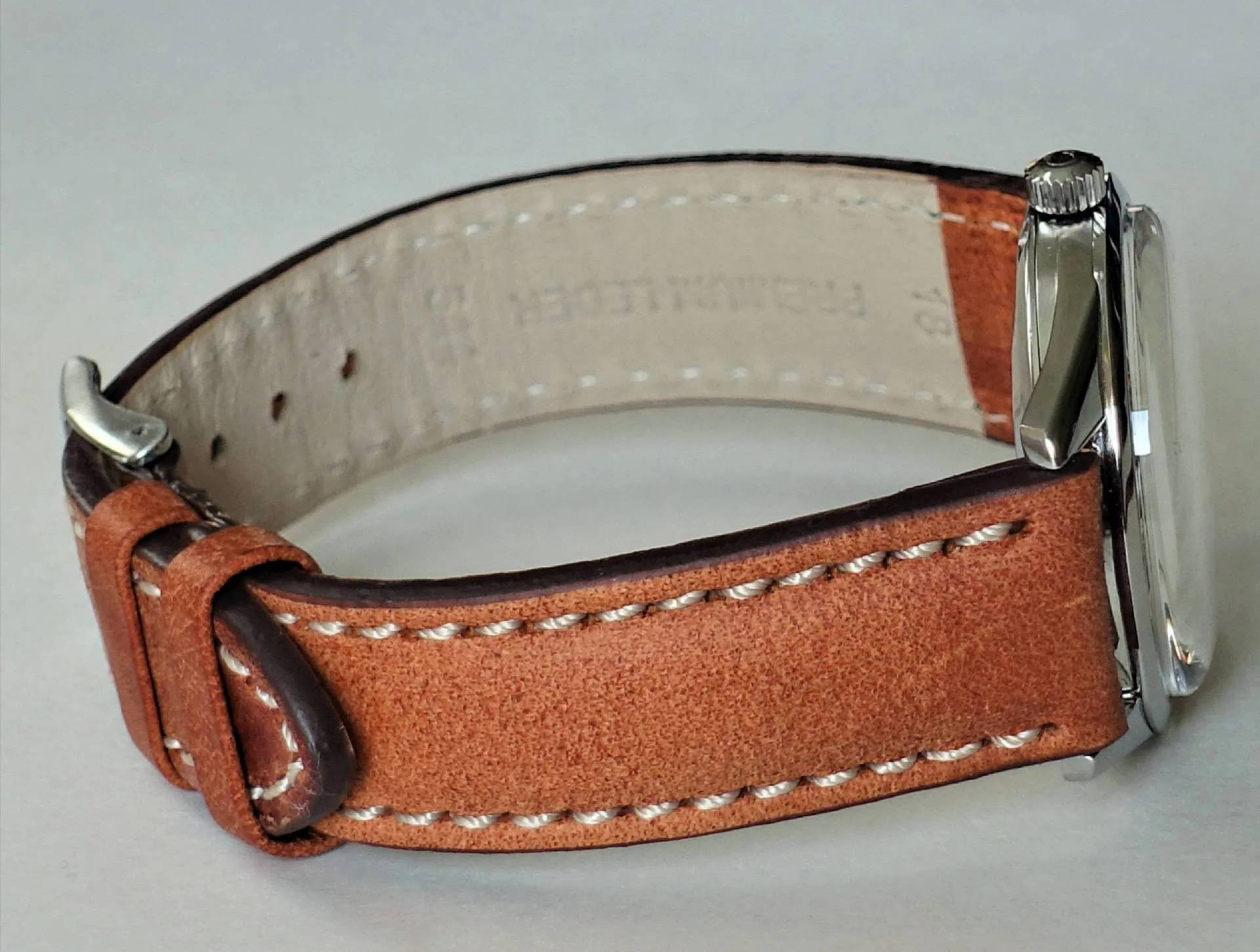 Armbanduhr braunes Lederarmband Armbanduhr mit braunem Lederarmband und silberfarbenem Gehäuse.