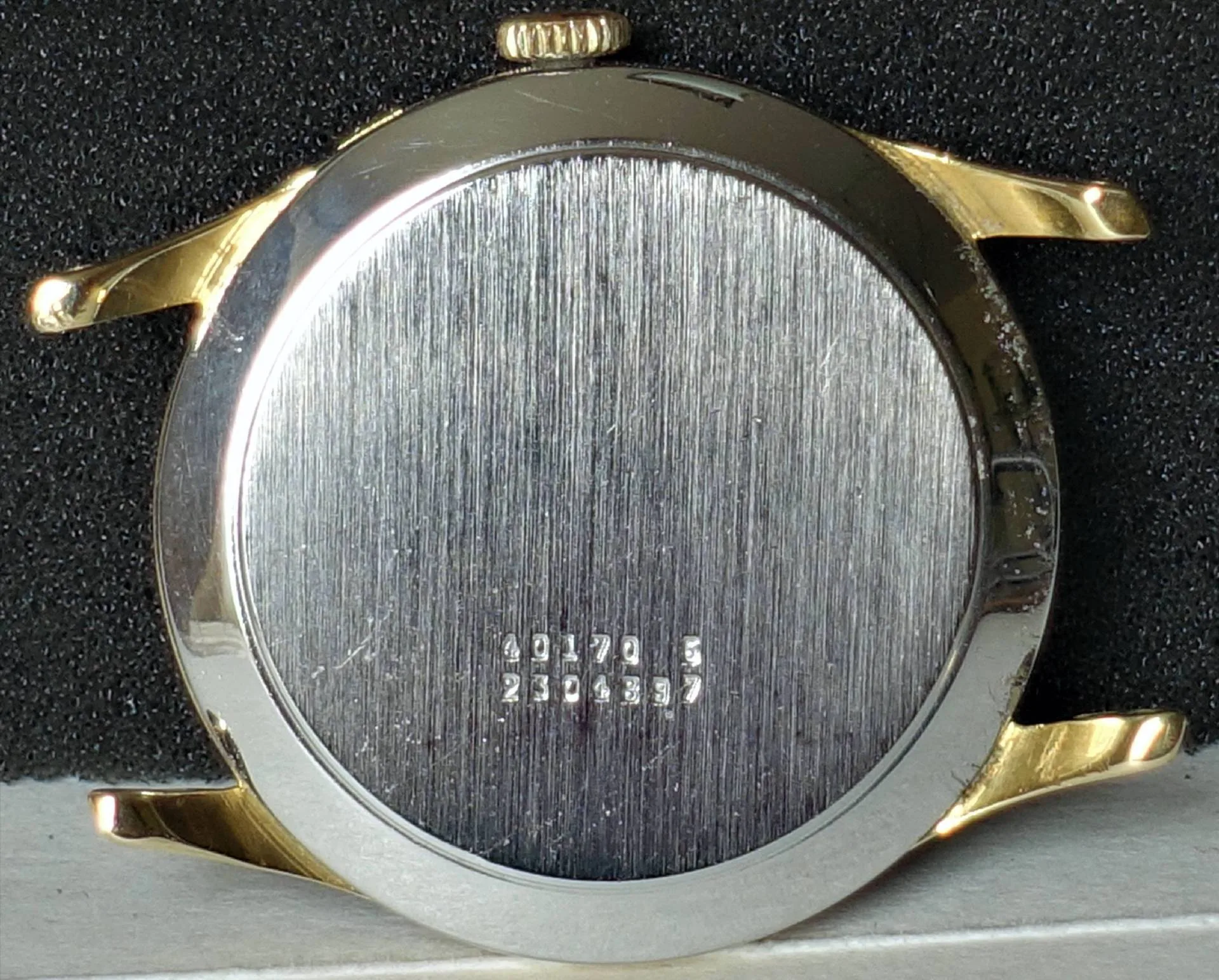 Gehäuse zweifarbig Rundes Uhrengehäuse mit silberfarbener Rückseite und goldfarbenen Hörnern.