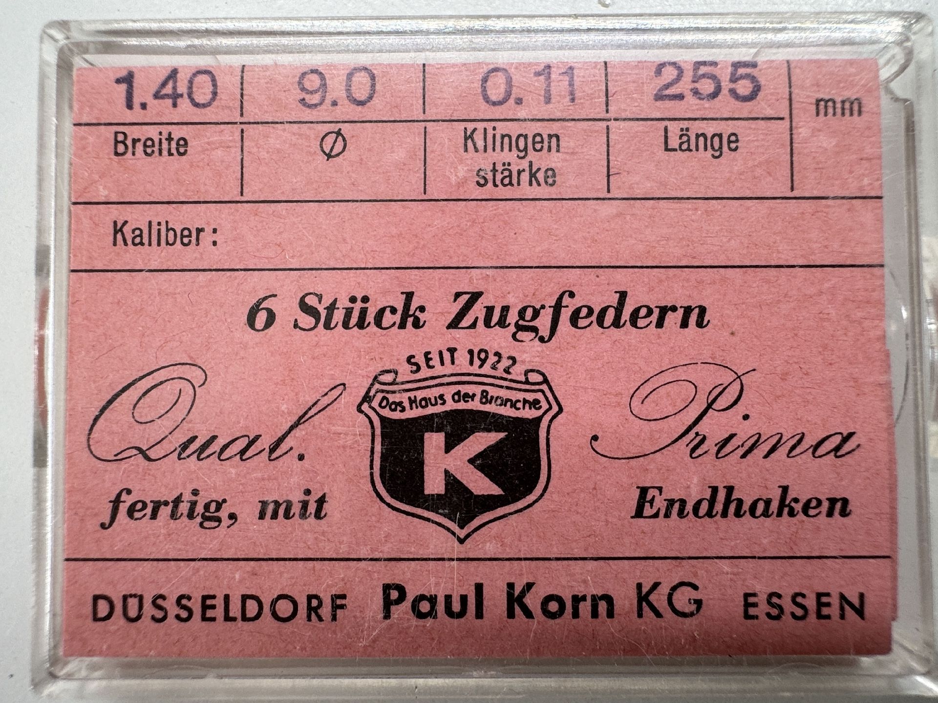 Sechs Zugfedern für Uhrwerke in einer Verpackung mit rosa Etikett.