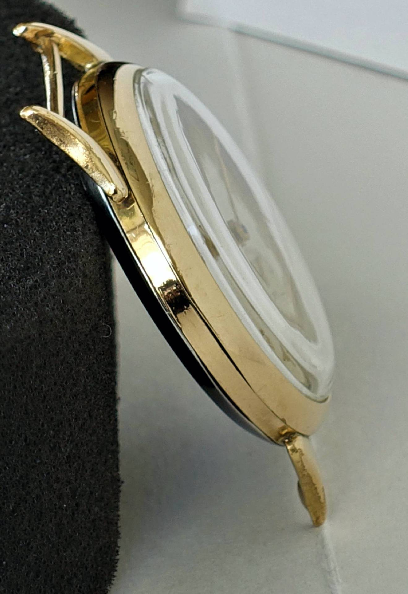 Rundes Uhrgehäuse in goldfarbener Ausführung mit montiertem Uhrglas.