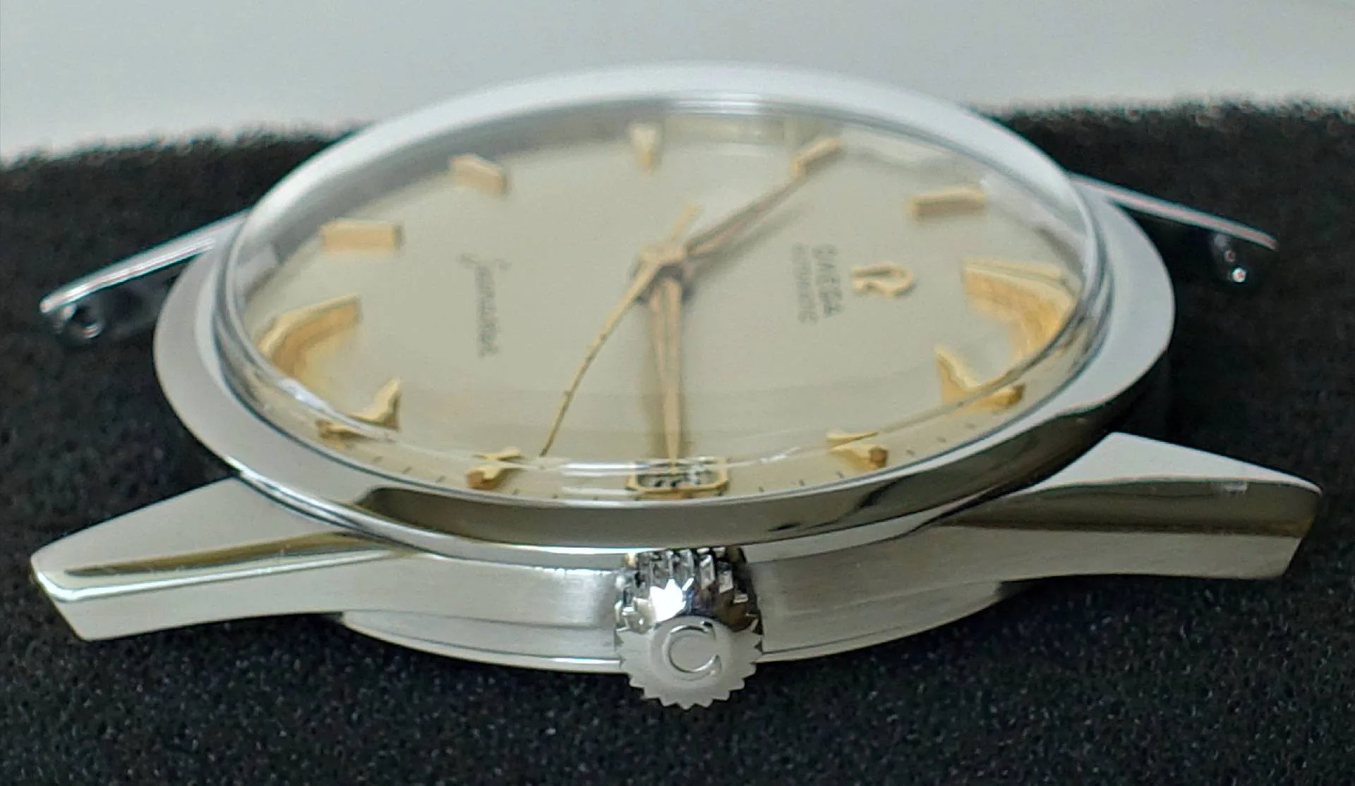 Silberfarbene Armbanduhr mit hellem Zifferblatt und goldfarbenen Zeigern und Indizes.