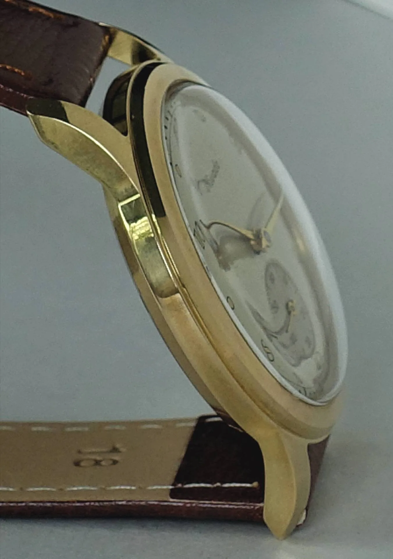 Armbanduhr goldfarben braun Goldfarbene Armbanduhr mit braunem Lederarmband und hellem Zifferblatt.