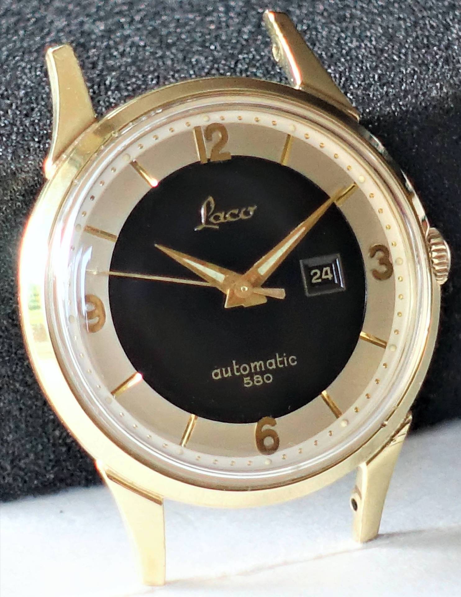 Goldfarbene Armbanduhr mit schwarzem Zifferblatt und Datumsanzeige.