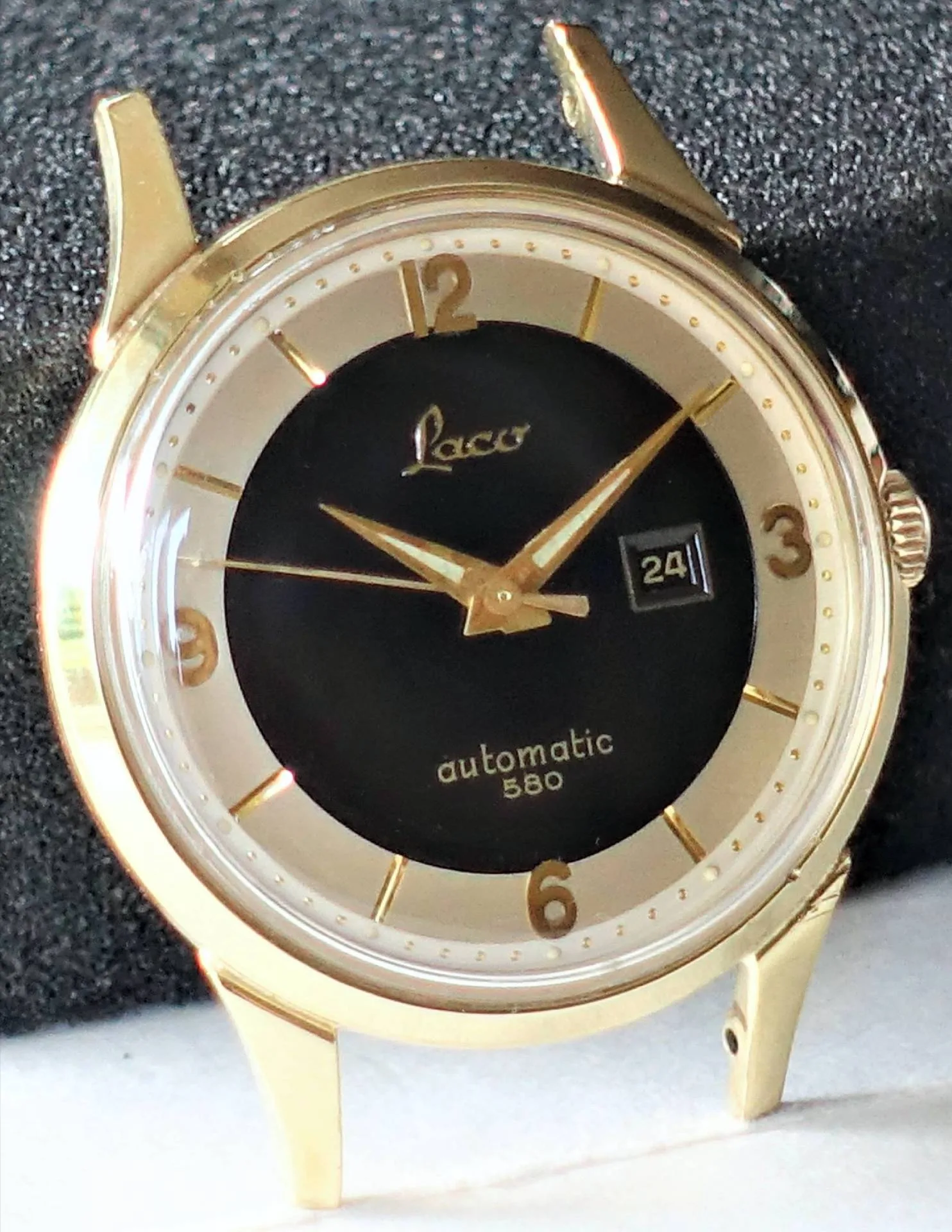 Goldfarbene Armbanduhr mit schwarzem Zifferblatt und Datumsanzeige.