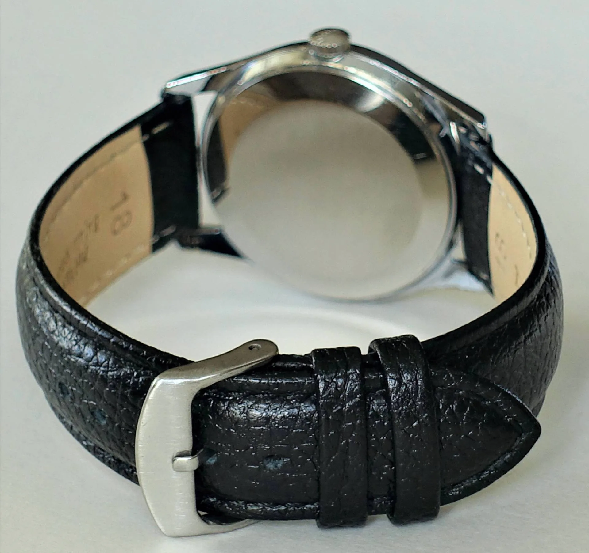 Armbanduhr schwarz Schwarze Armbanduhr mit rundem silberfarbenem Gehäuse und schwarzem Lederarmband.