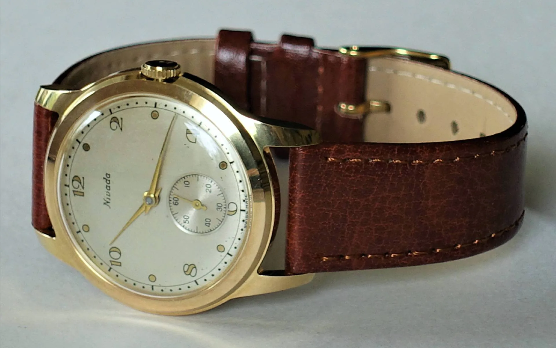 Armbanduhr goldfarben braun Goldfarbene Armbanduhr mit braunem Lederarmband und hellem Zifferblatt.