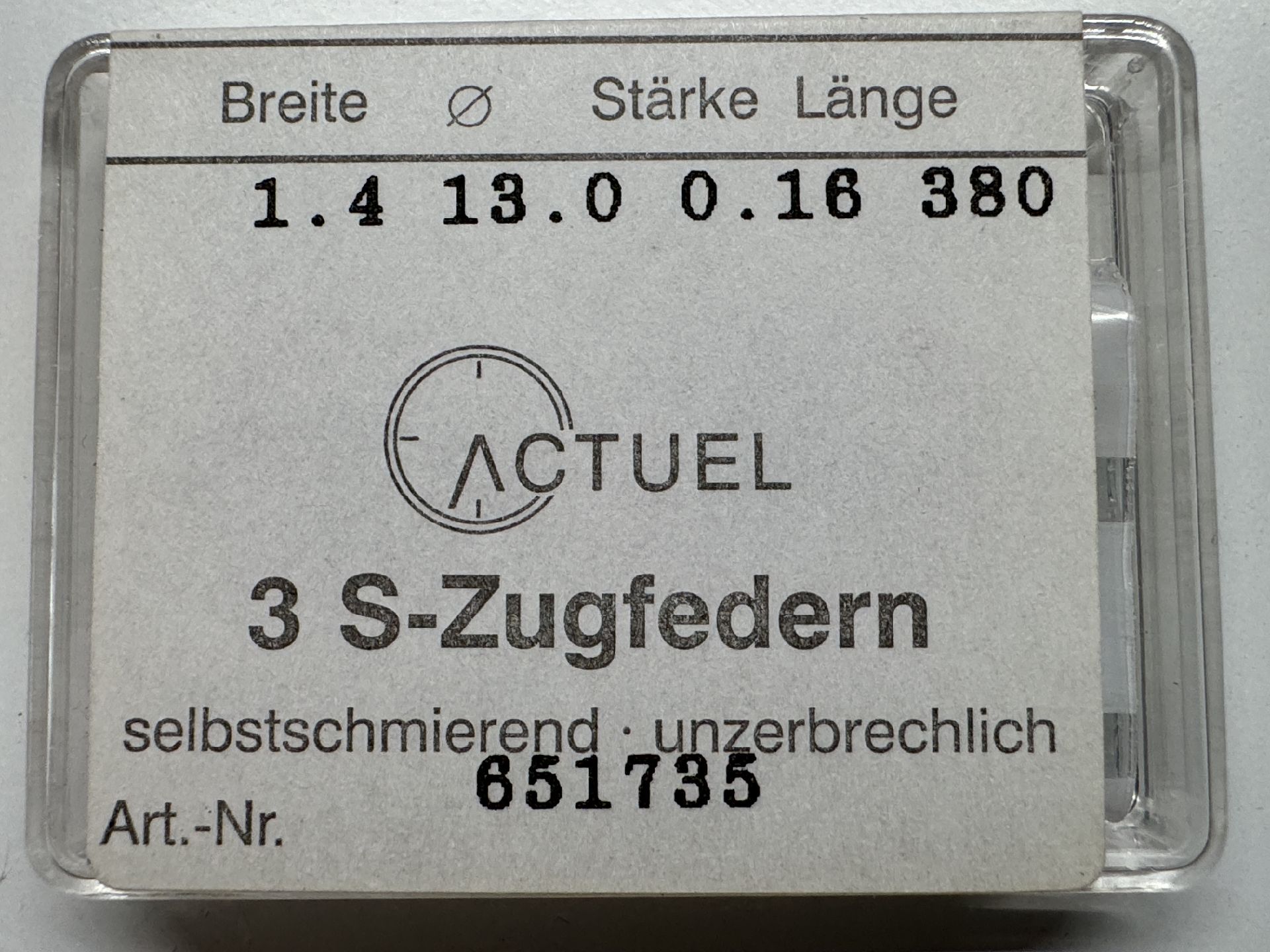 Set mit drei silberfarbenen Zugfedern für Uhren in transparenter Verpackung.