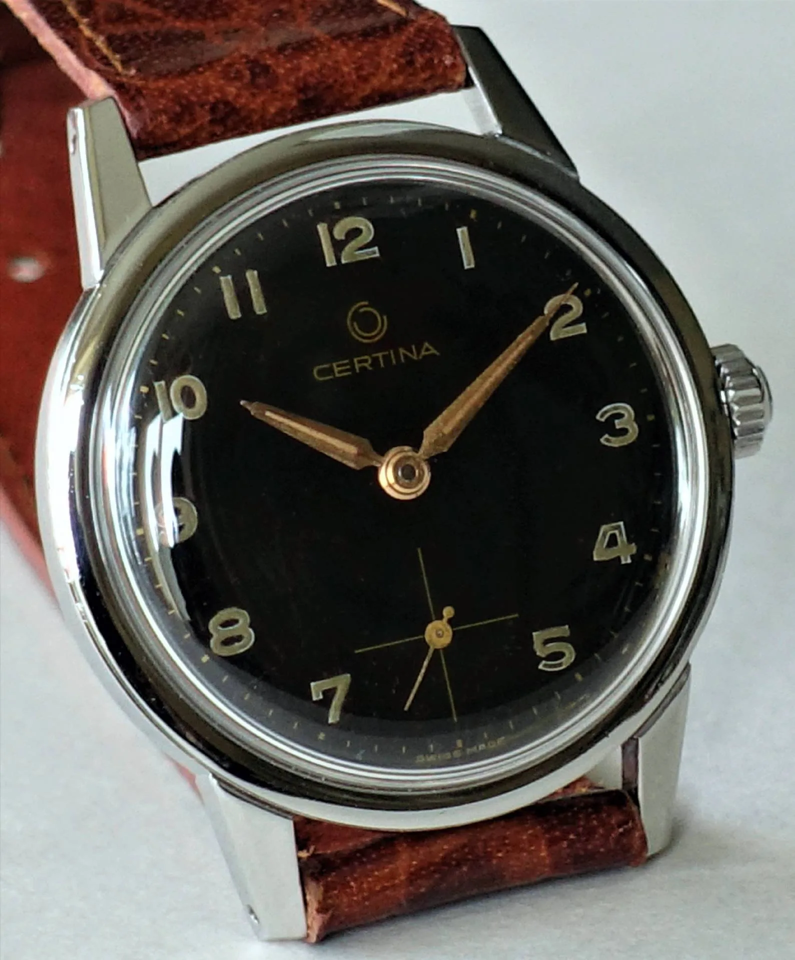 Schwarze Certina Armbanduhr mit silberfarbenem Gehäuse und braunem Armband.