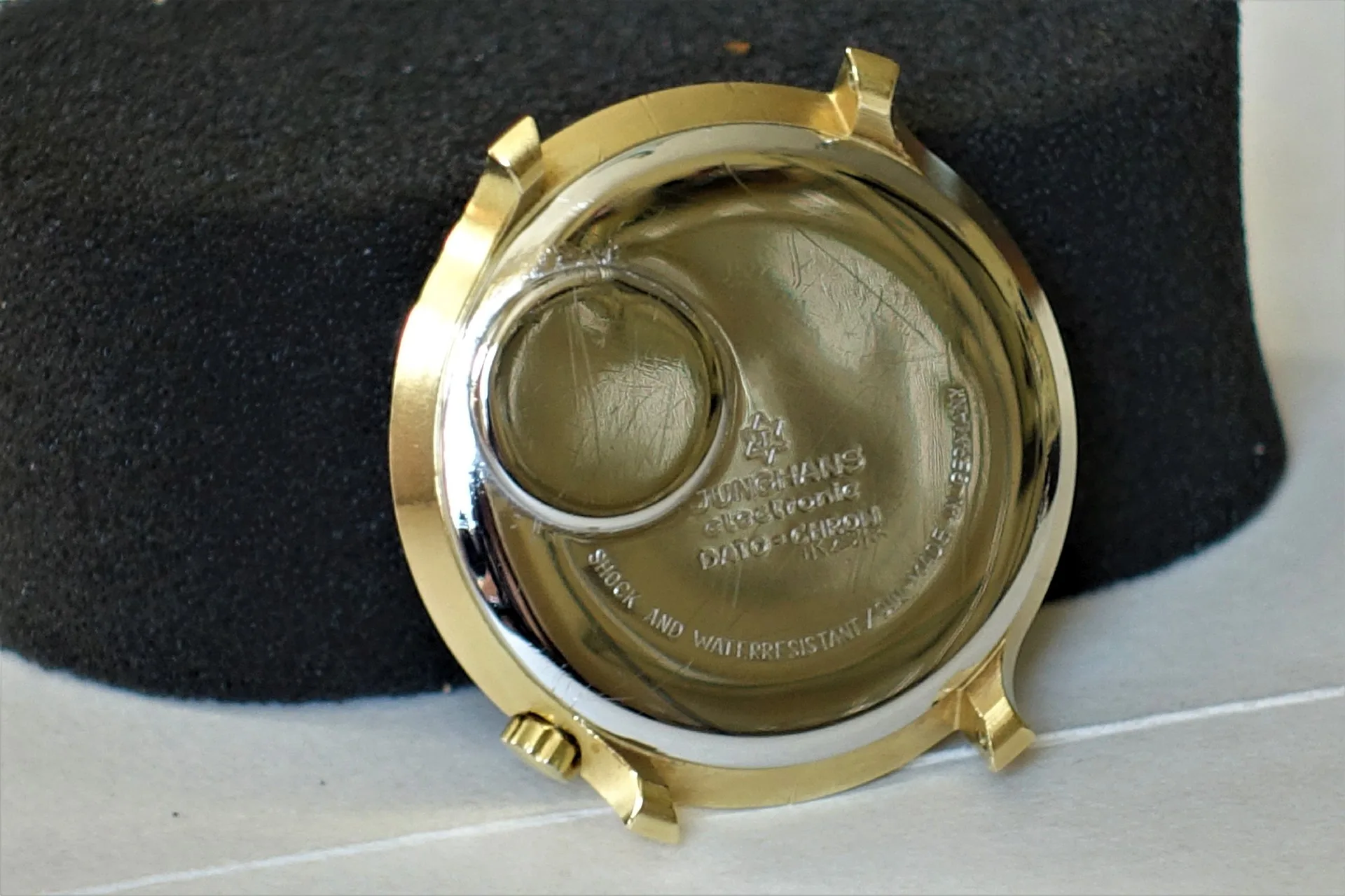 Rundes Uhrgehäuse in goldfarbener Ausführung mit sichtbarer Gravur auf der Innenseite.