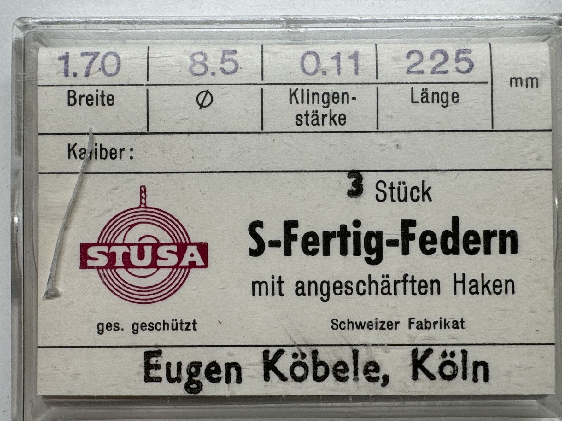 Drei silberfarbene Fertigfedern mit angeschärften Haken für Uhren in transparenter Verpackung.