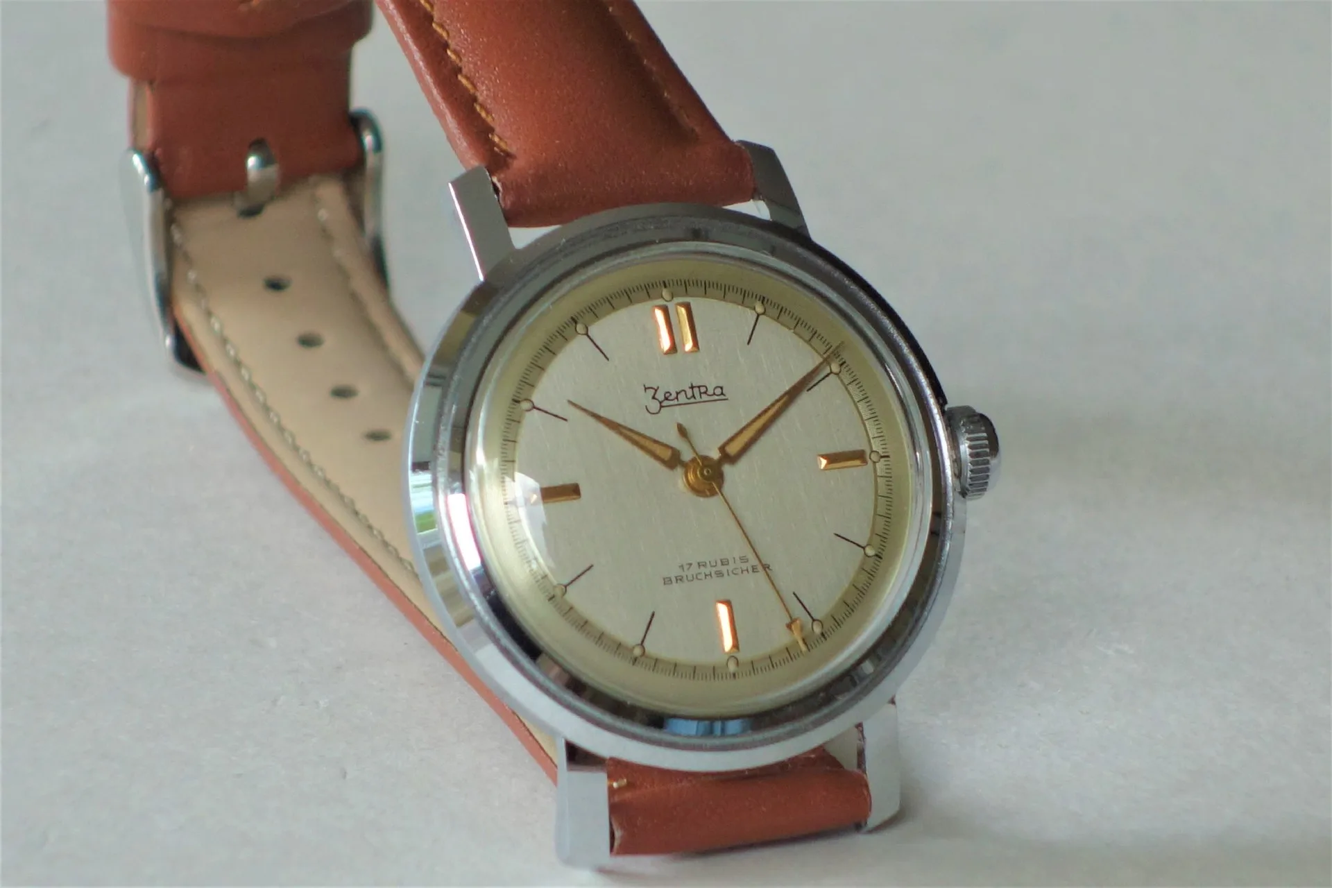 Mechanische Armbanduhr braun Mechanische Armbanduhr mit beigem Zifferblatt, silberfarbenem Gehäuse und braunem Armband.