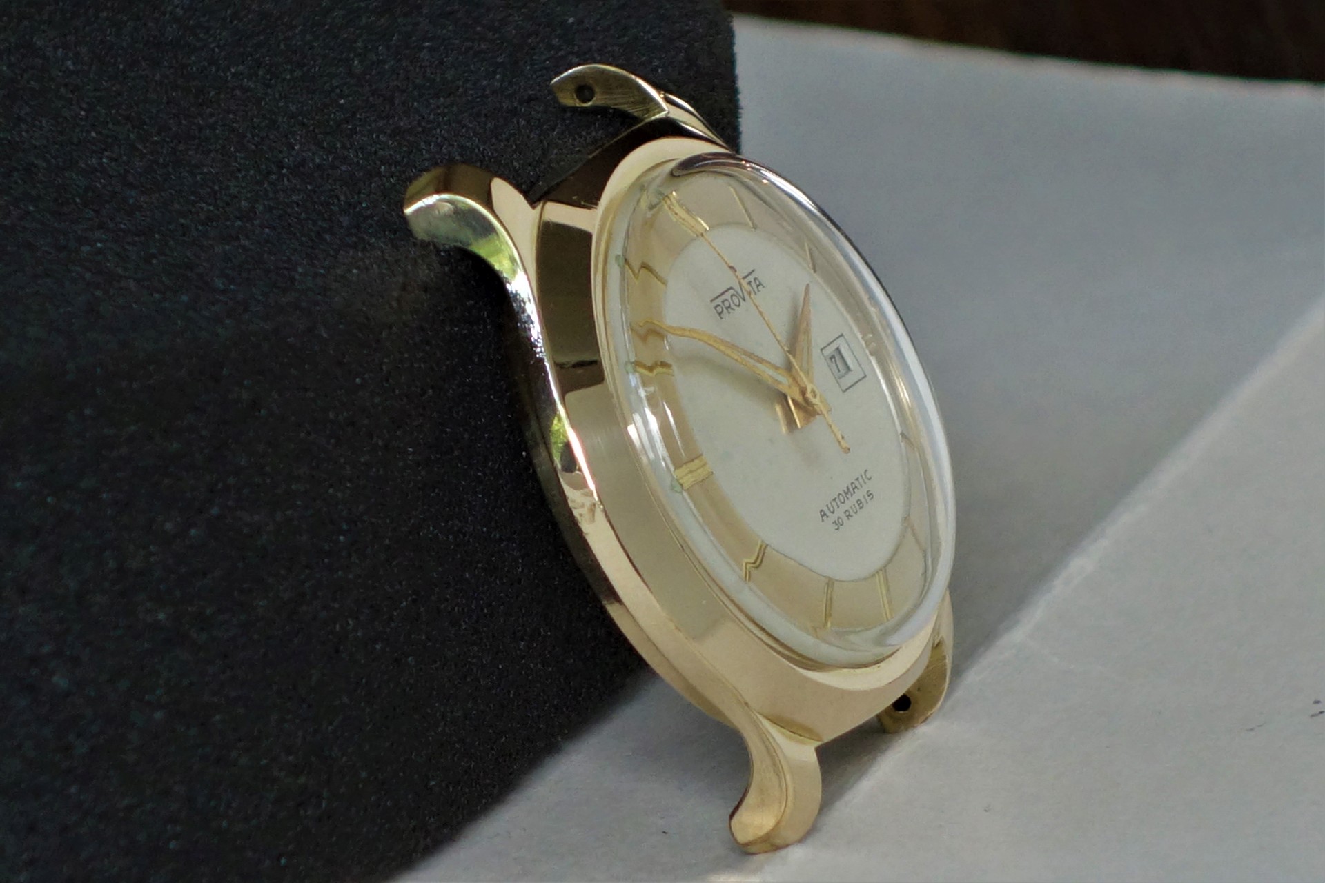 Goldfarbene Armbanduhr mit hellem Zifferblatt und Datumsanzeige.