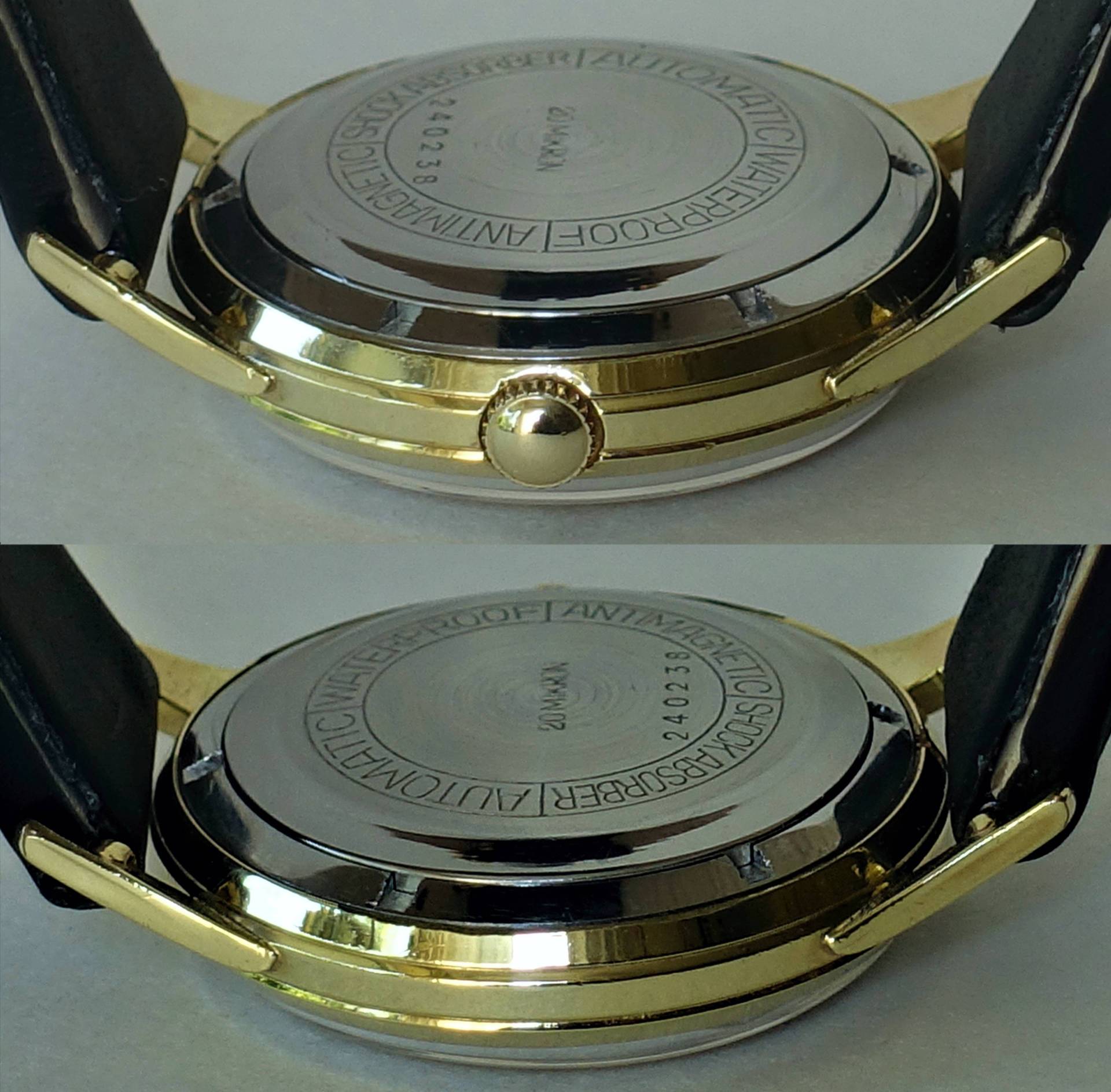 Rundes Uhrengehäuse in goldfarbener und silberfarbener Optik mit schwarzem Armband und sichtbarem Gehäuseboden.
