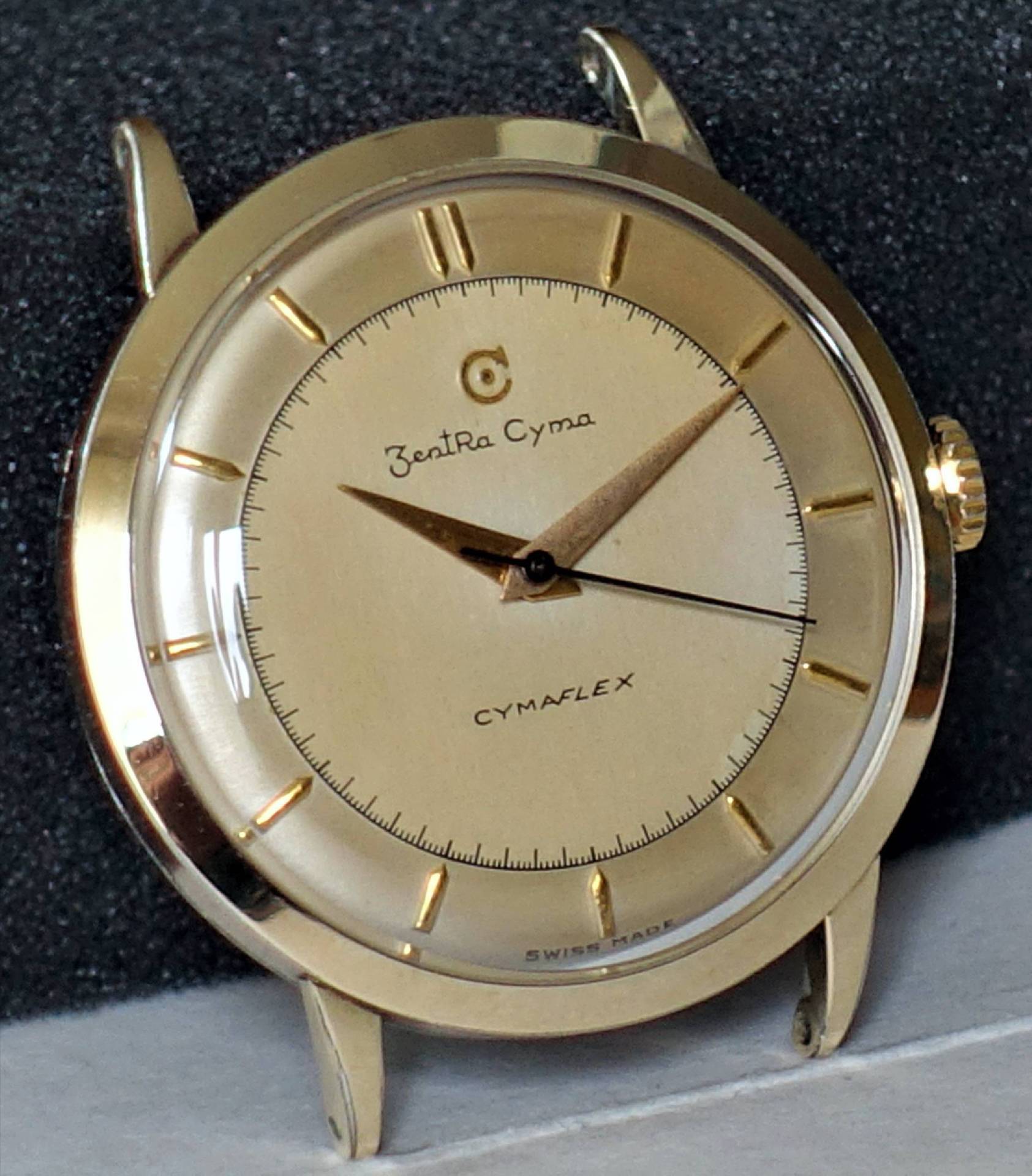 Goldfarbene Armbanduhr mit hellem Zifferblatt und goldenen Zeigern.