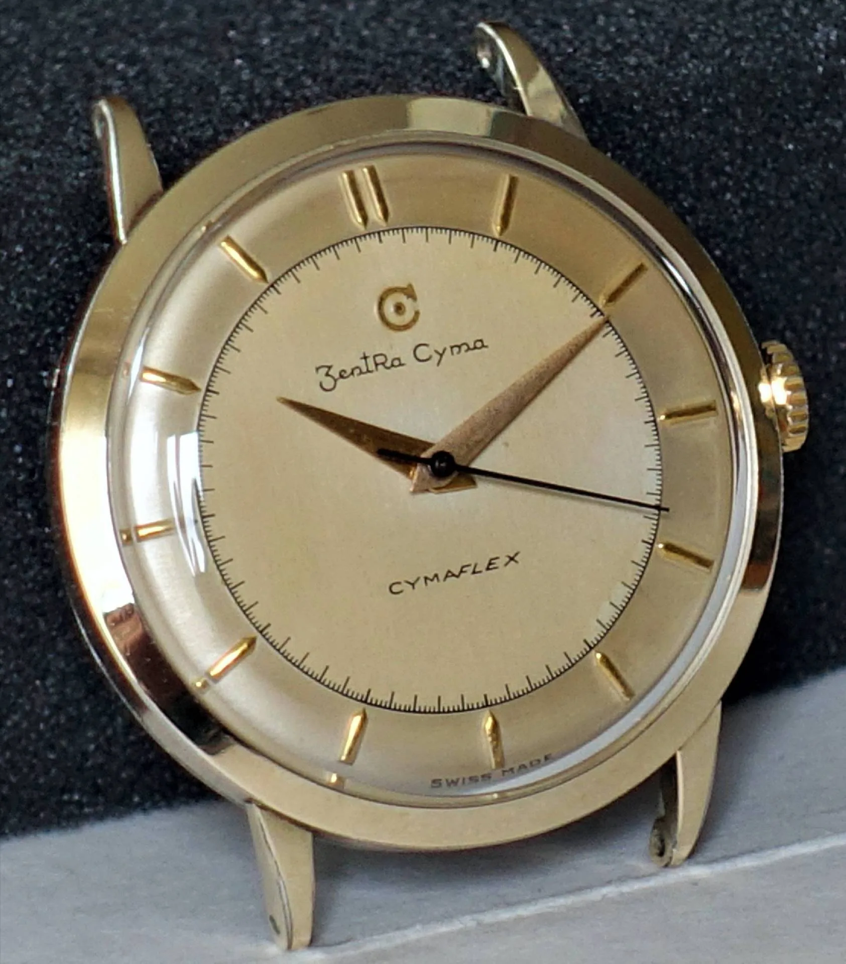 Goldfarbene Armbanduhr mit hellem Zifferblatt und goldenen Zeigern.
