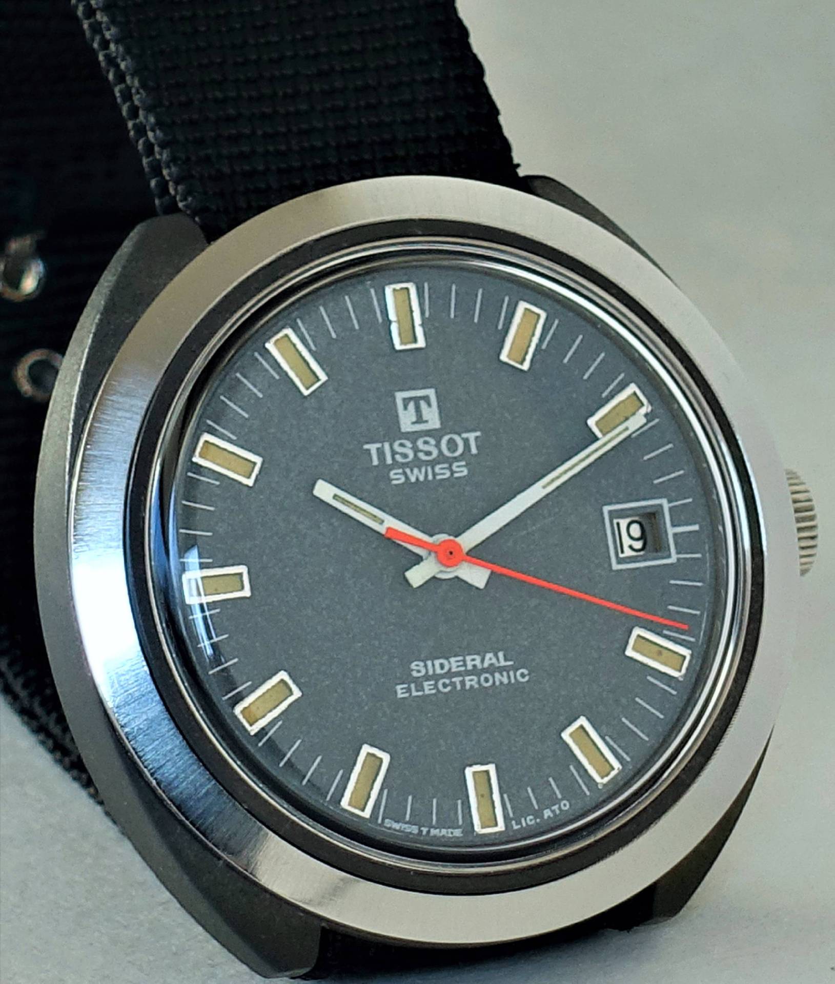 Nahaufnahme einer Tissot Sidereal Electronic Uhr mit grauem Ziffernblatt und schwarzem Textilarmband