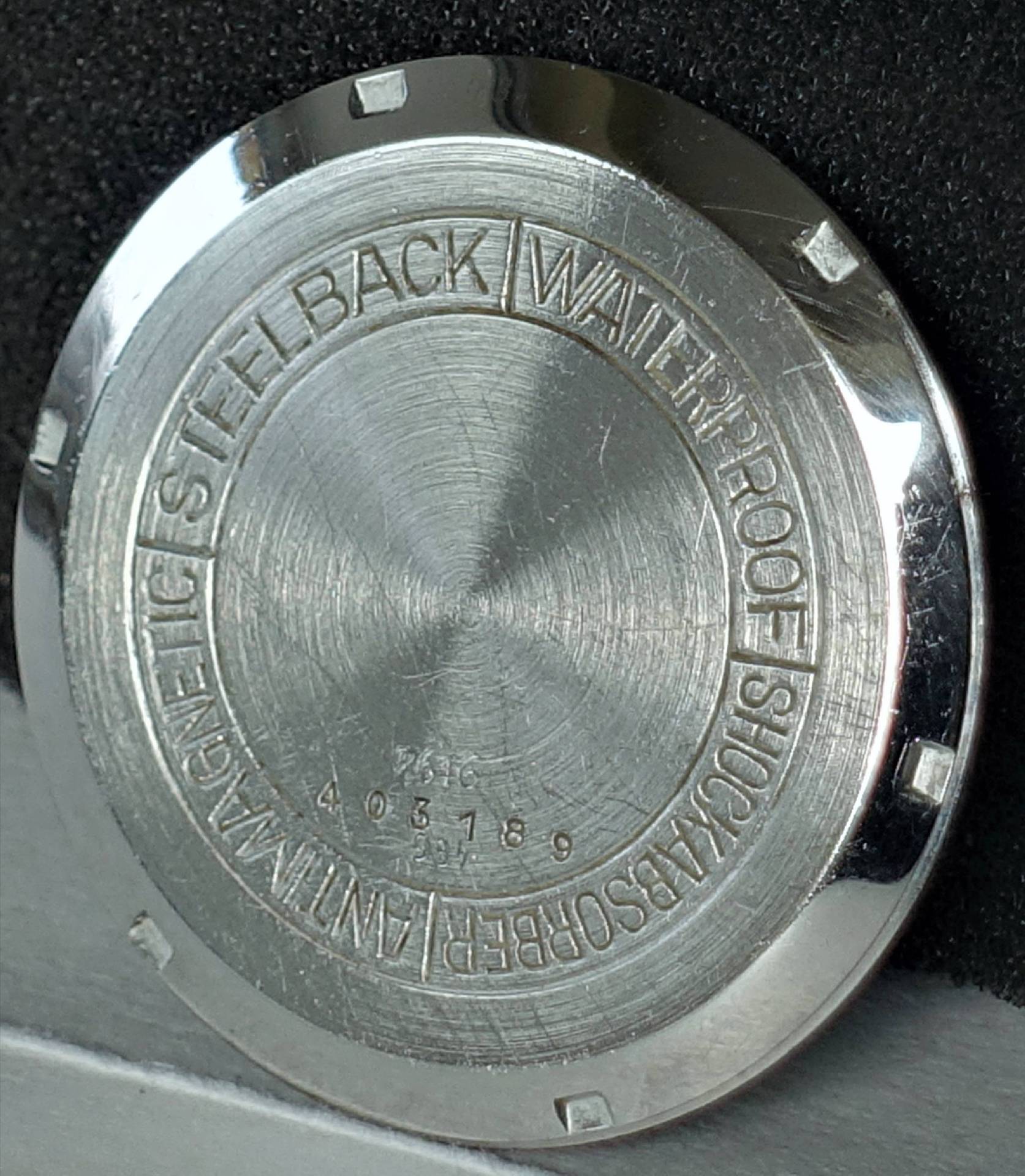 Silberfarbener Gehäuseboden für Armbanduhren mit Gravur.