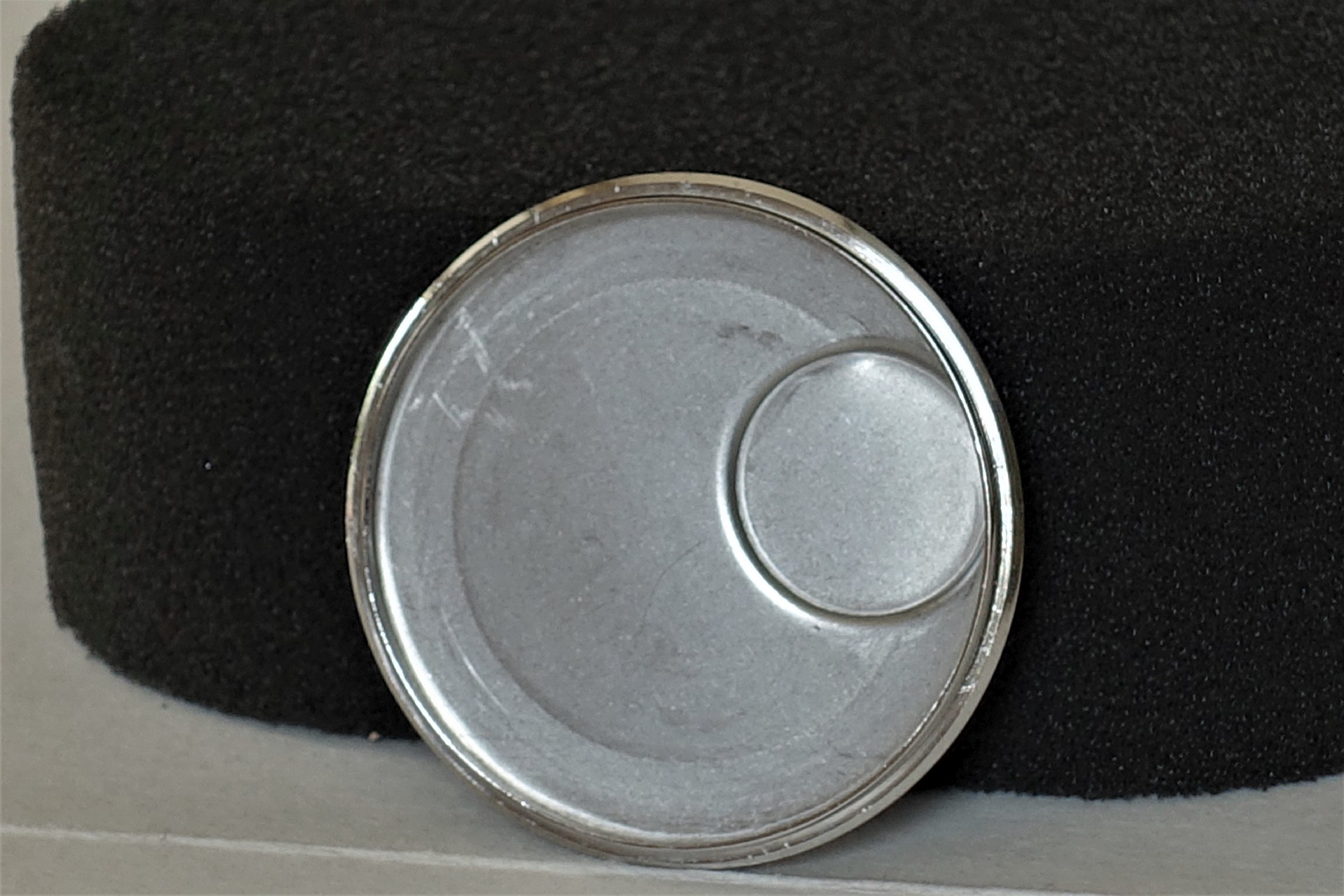 Runder silberfarbener Uhrenboden aus Metall mit glatter Oberfläche.