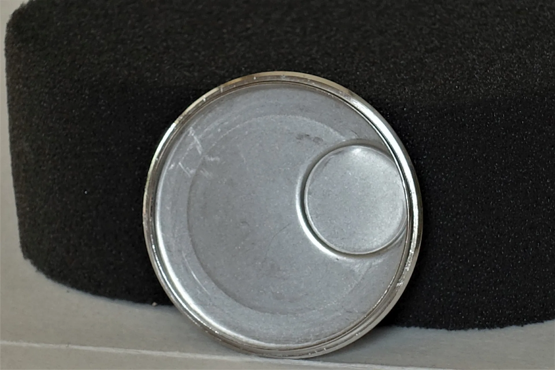 Uhrenboden silberfarben Runder silberfarbener Uhrenboden aus Metall mit glatter Oberfläche.
